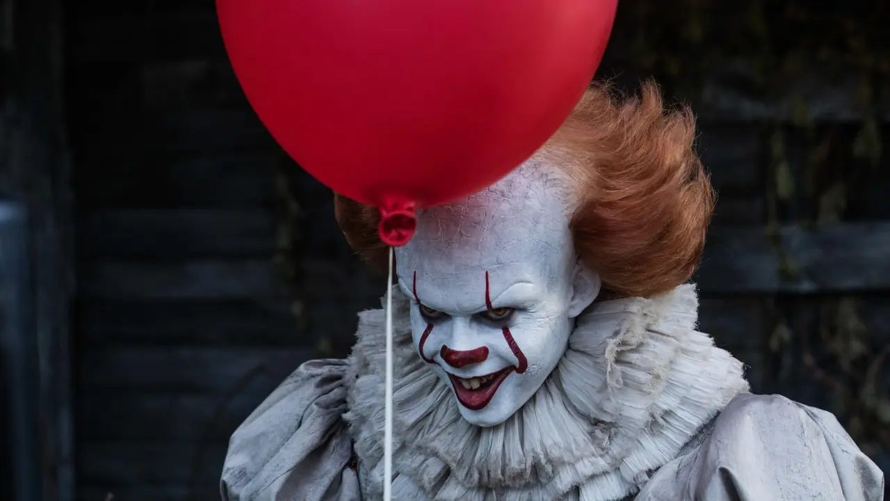 Palhaço Pennywise do filme It, a Coisa (2017), segurando um balão vermelho